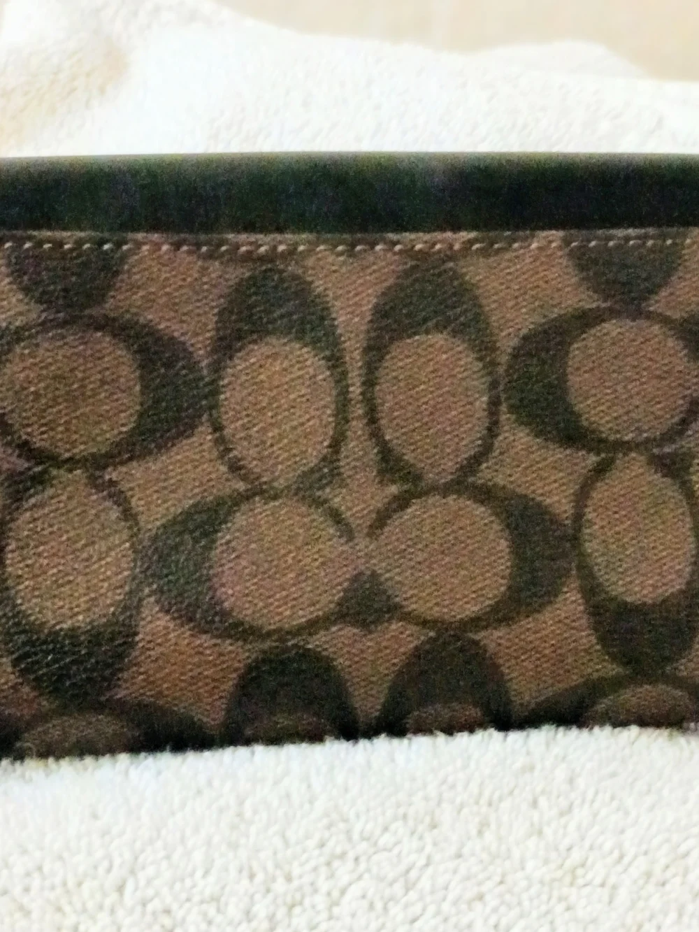 This Coach Signature PVC Slim Envelope Wallet features a brown monogram canvas b
